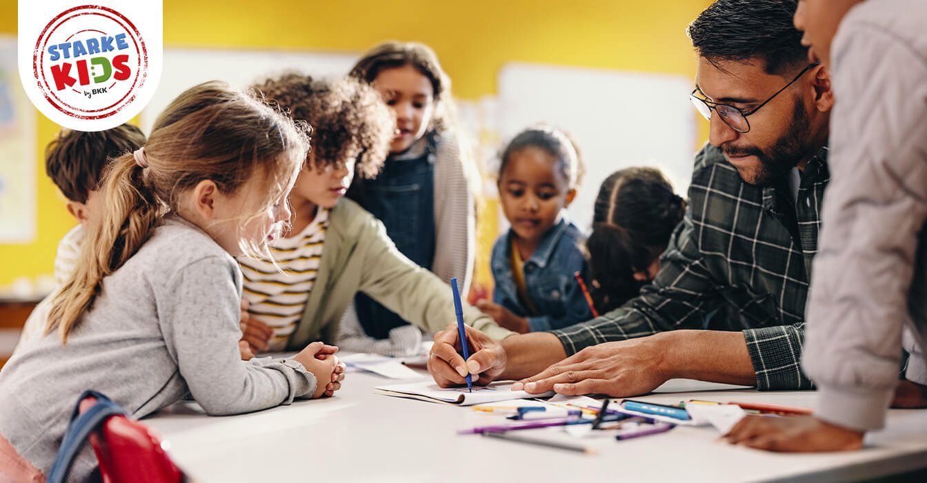 Ein Lehrer hilft einer Gruppe konzentrierter Kinder beim Lernen in einem lebendigen Klassenzimmer.