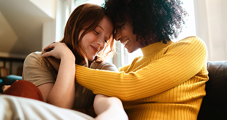 Zwei Frauen Arm in Arm auf dem Sofa